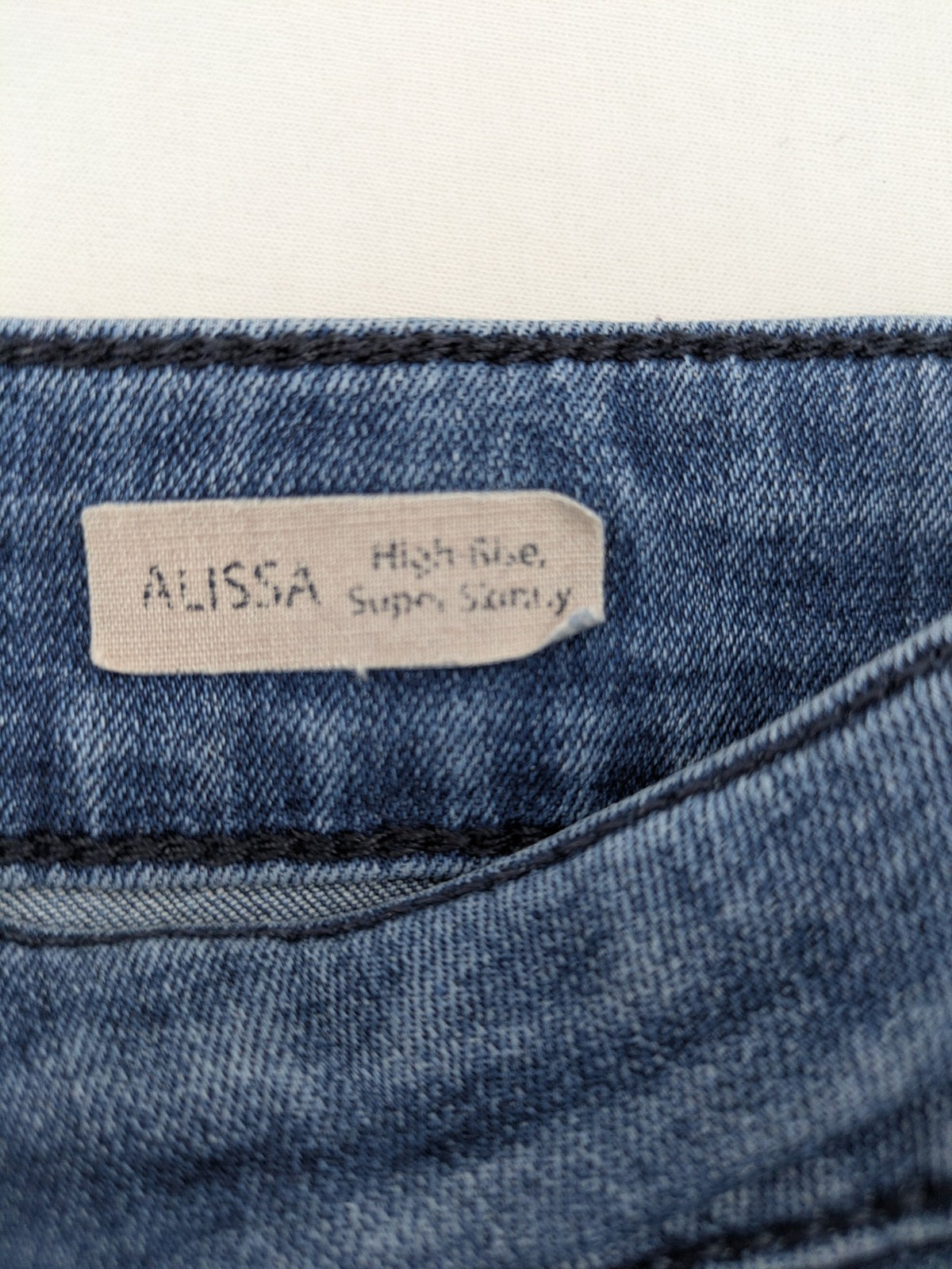 Mavi blue high rise super skinny jeans with medium wash and stretch denim material.