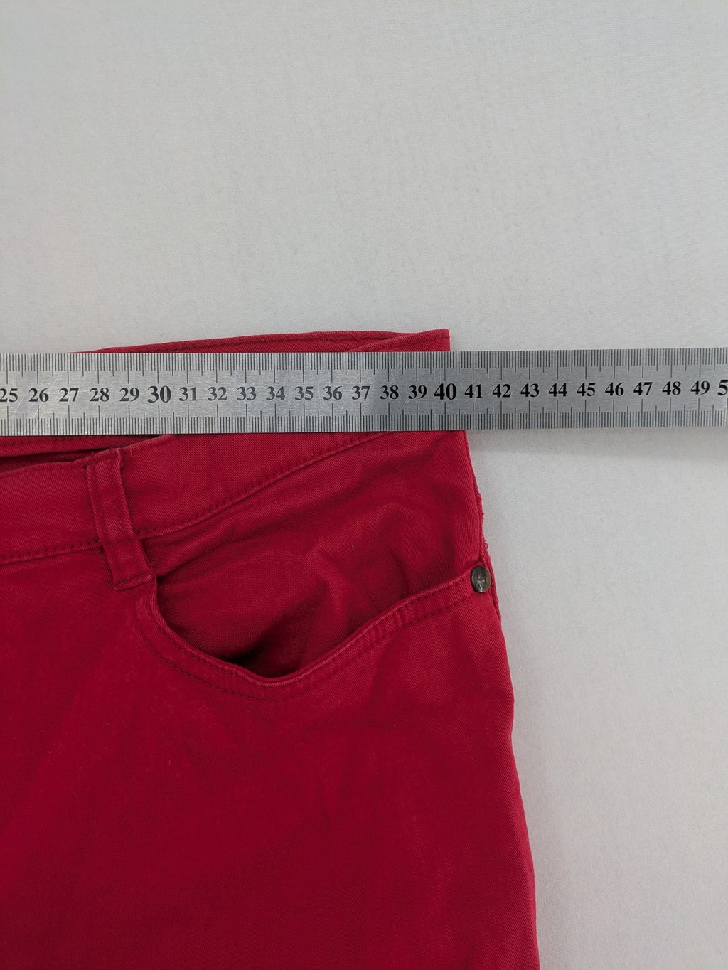 Jet Line red bootcut jeans with embroidered back pockets and pearl embellishments.