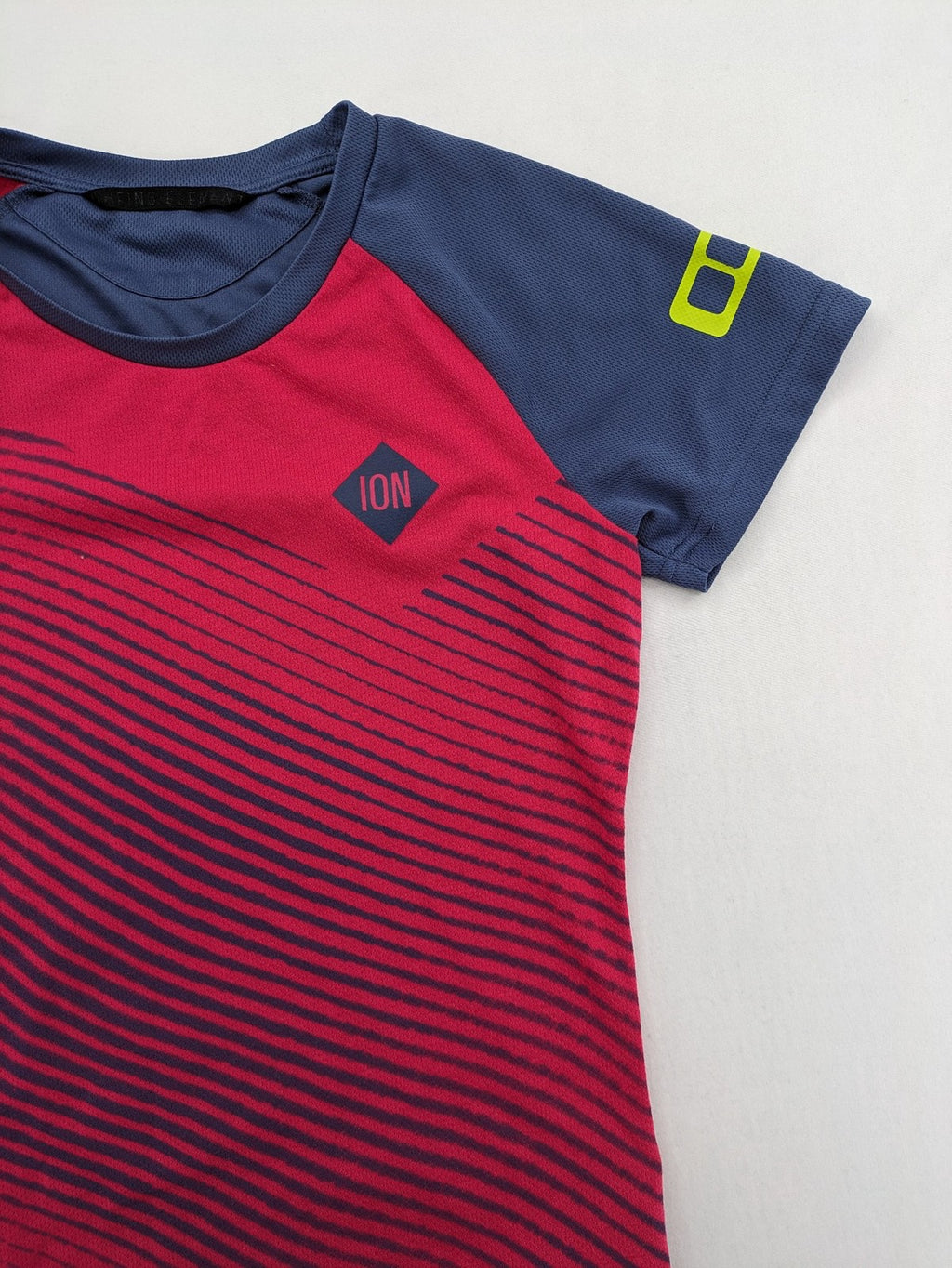 Muster blue and red short-sleeve functional shirt with dynamic wave pattern and raglan sleeves.