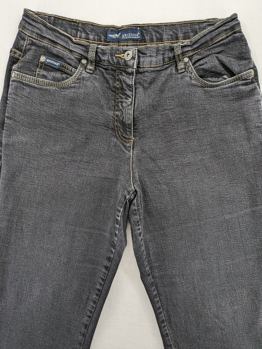 Bootcut grey low rise bootcut jeans five-pocket design with zipper and button closure.