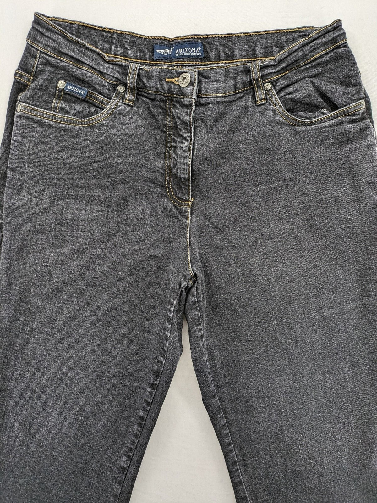 Bootcut grey low rise bootcut jeans five-pocket design with zipper and button closure.