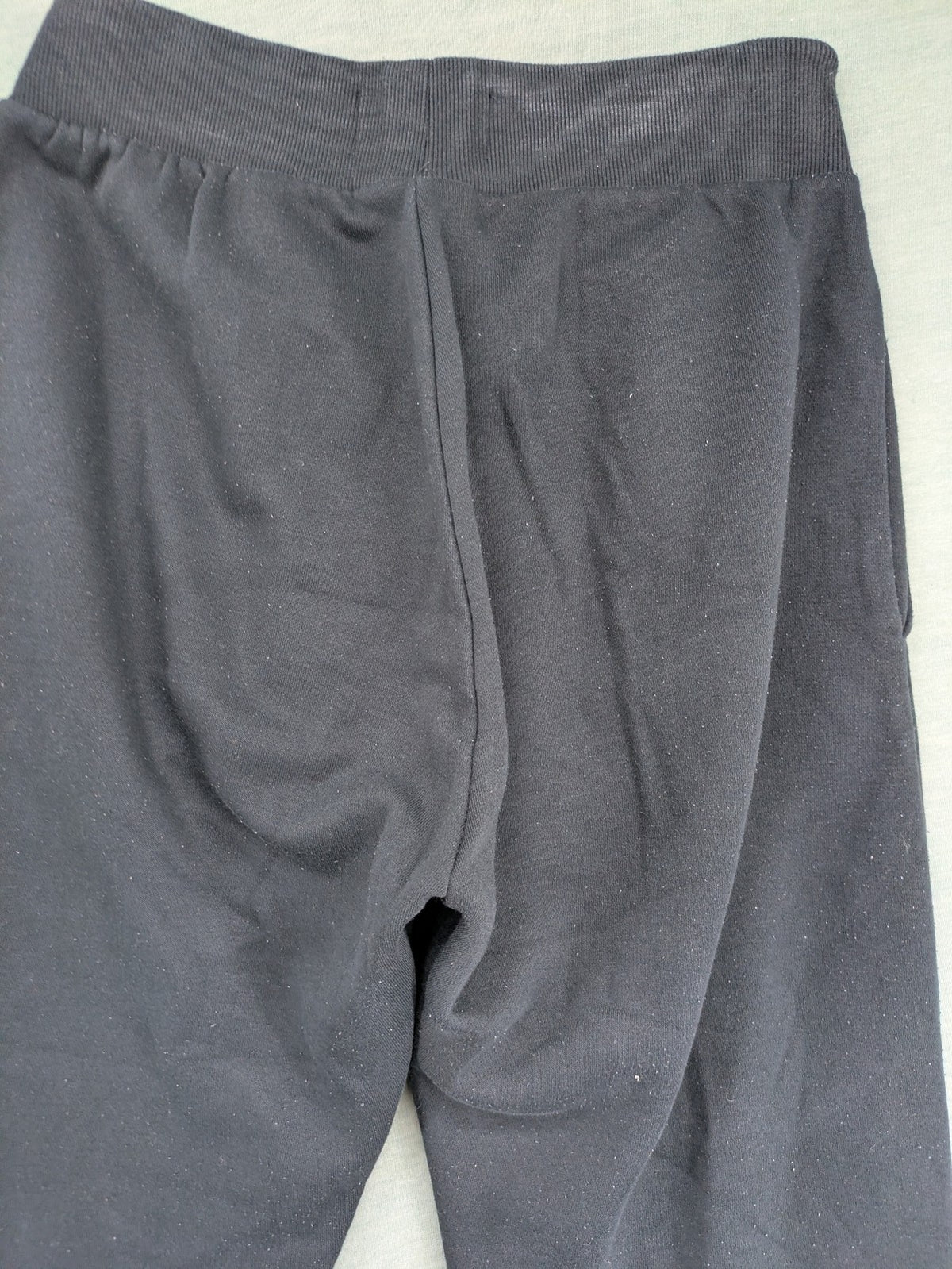 McKenzie black joggers with white logo, tapered fit, and ribbed ankle cuffs.