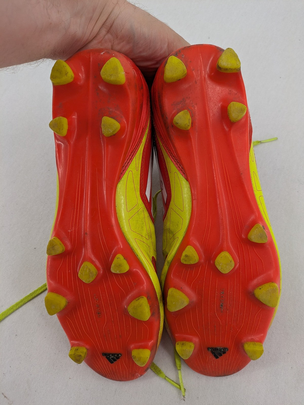 Adidas F50 soccer shoes red and yellow with three-stripe logo and lightweight synthetic material.
