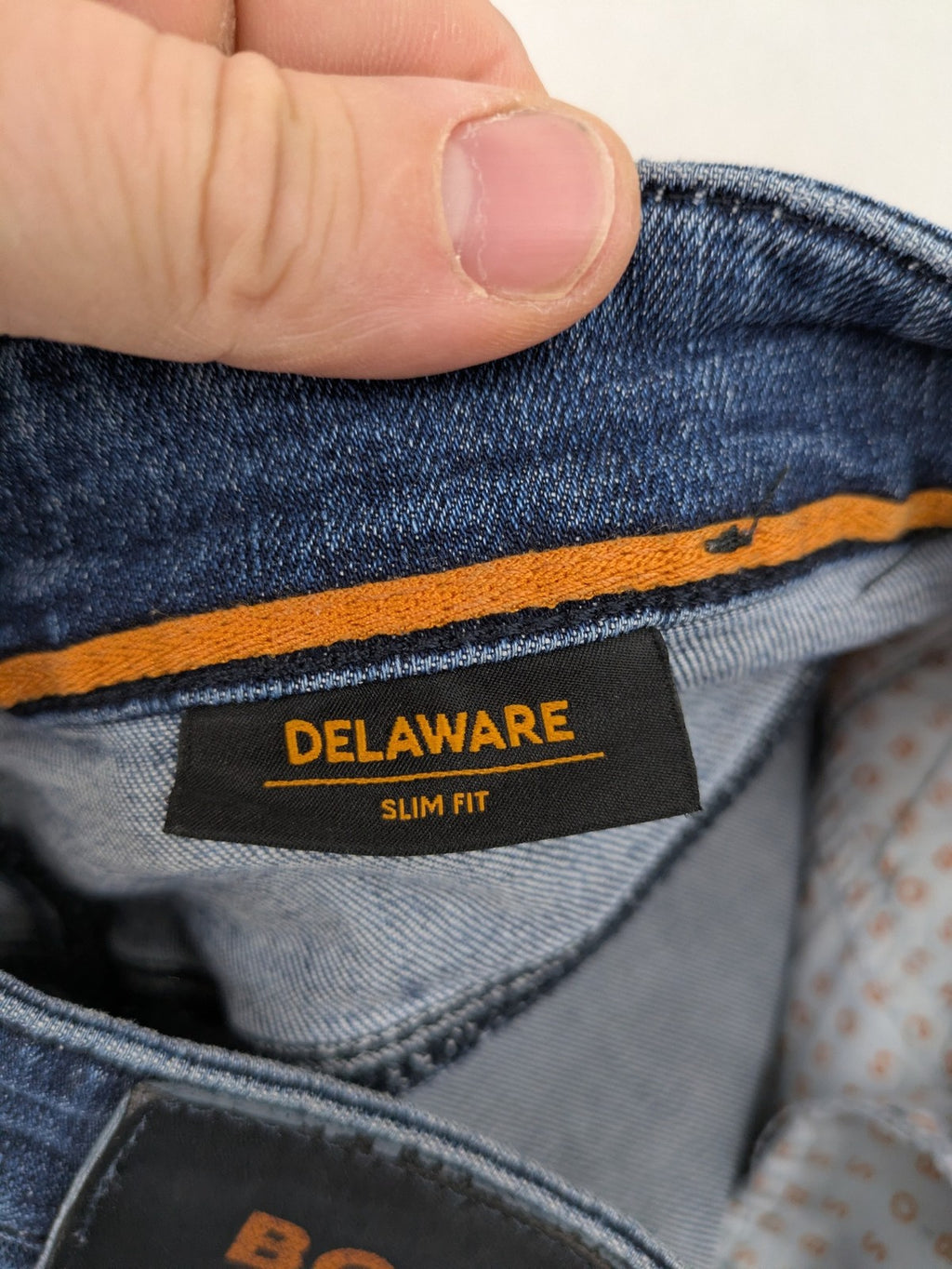 BOSS blue slim fit jeans with logo, five-pocket design, and button fly.