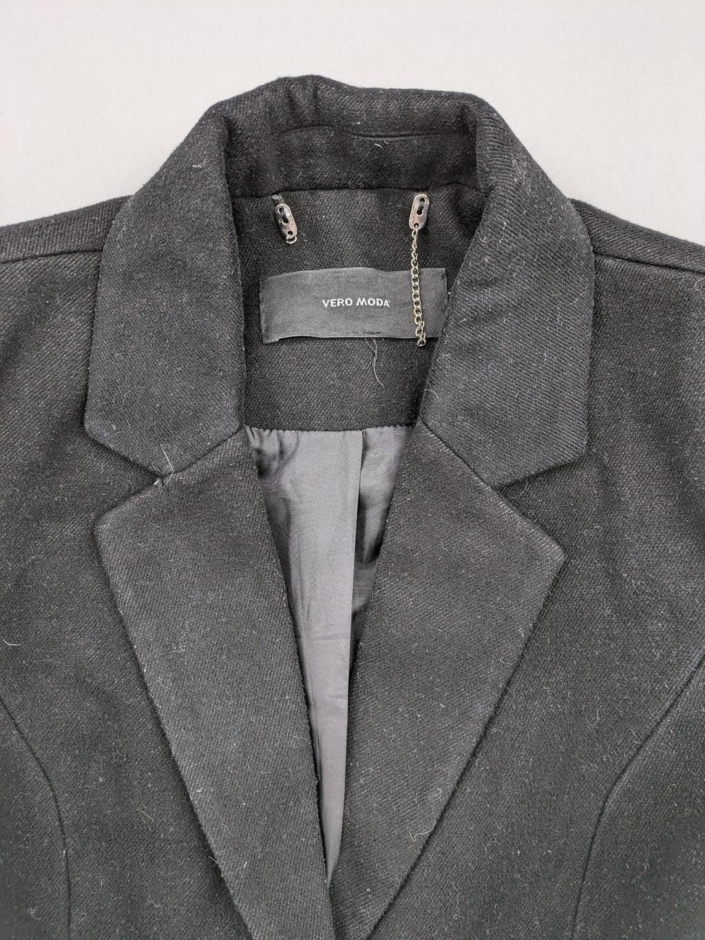 Vero Moda grey coat with classic lapel collar and button front, featuring two front pockets.