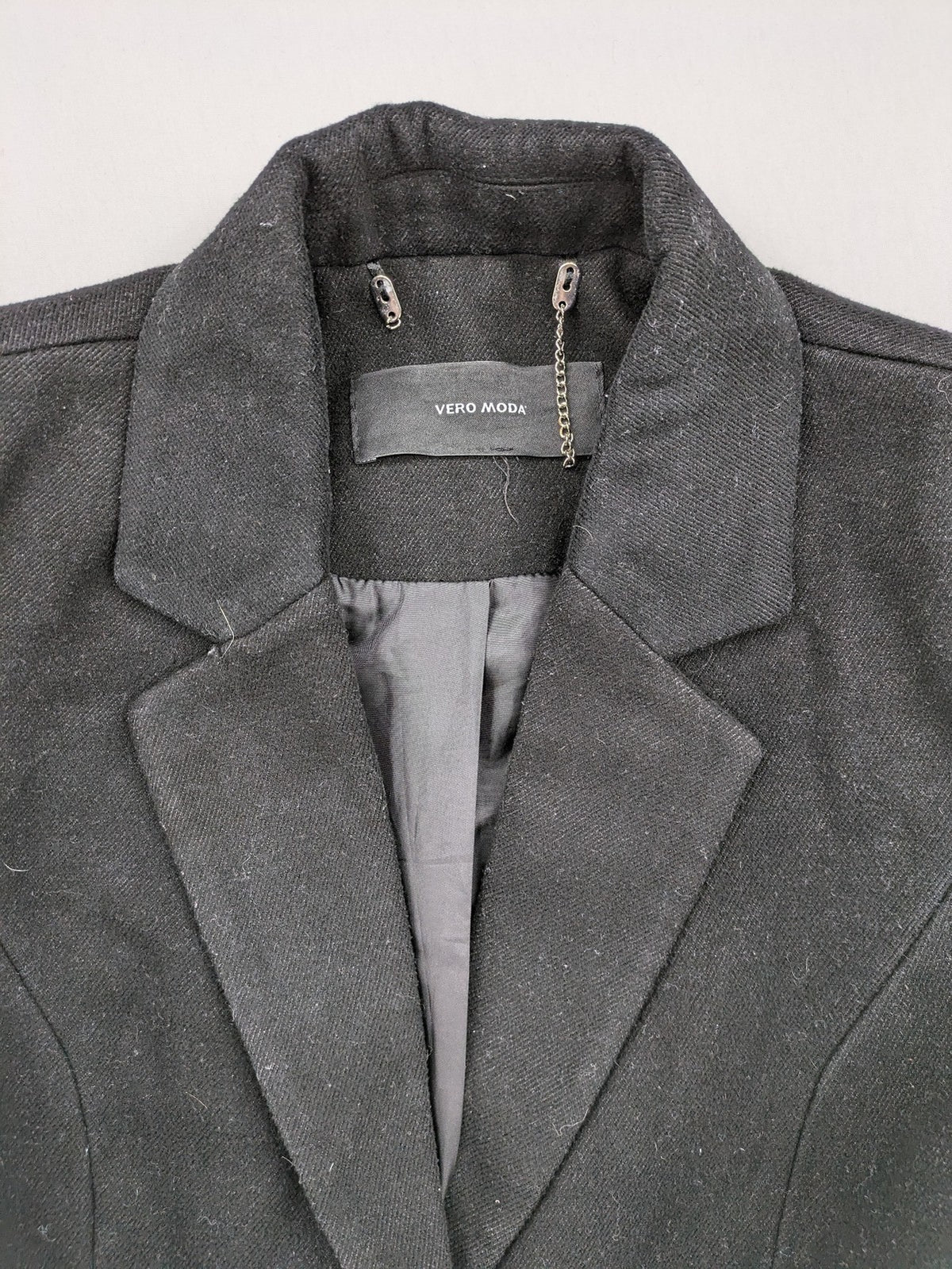 Vero Moda grey coat with classic lapel collar and button front, featuring two front pockets.