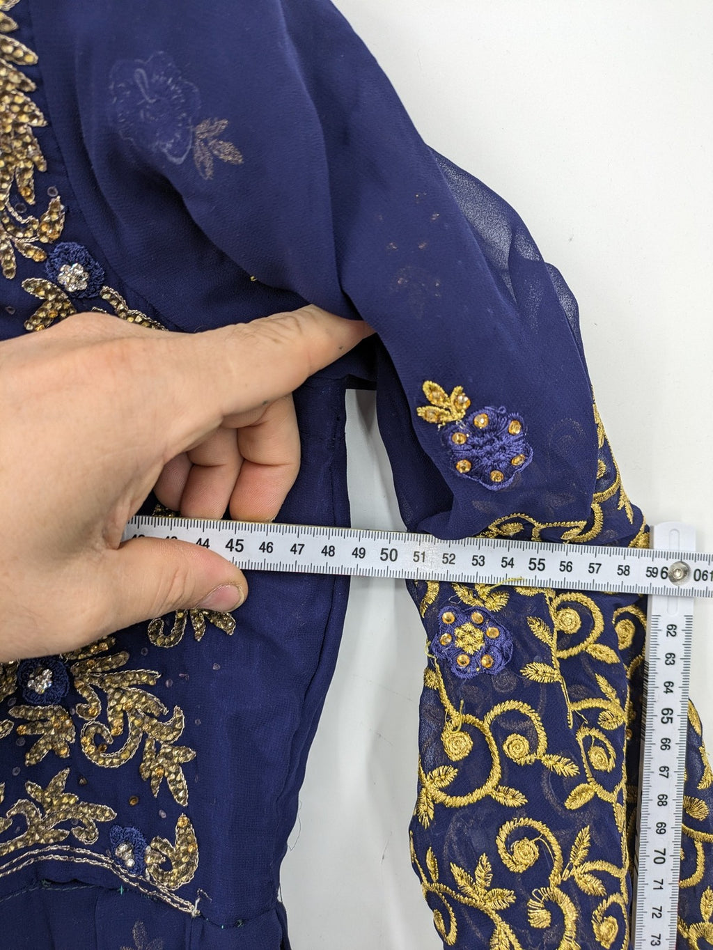 Bollywood bridal party dress gold with intricate blue embroidery and flowing Anarkali silhouette.