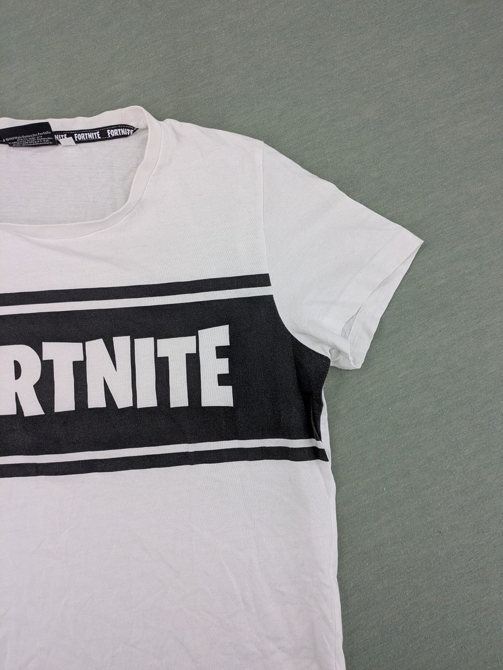 Fortnite white t-shirt with black chest stripe and Epic Games logo, 100% cotton.