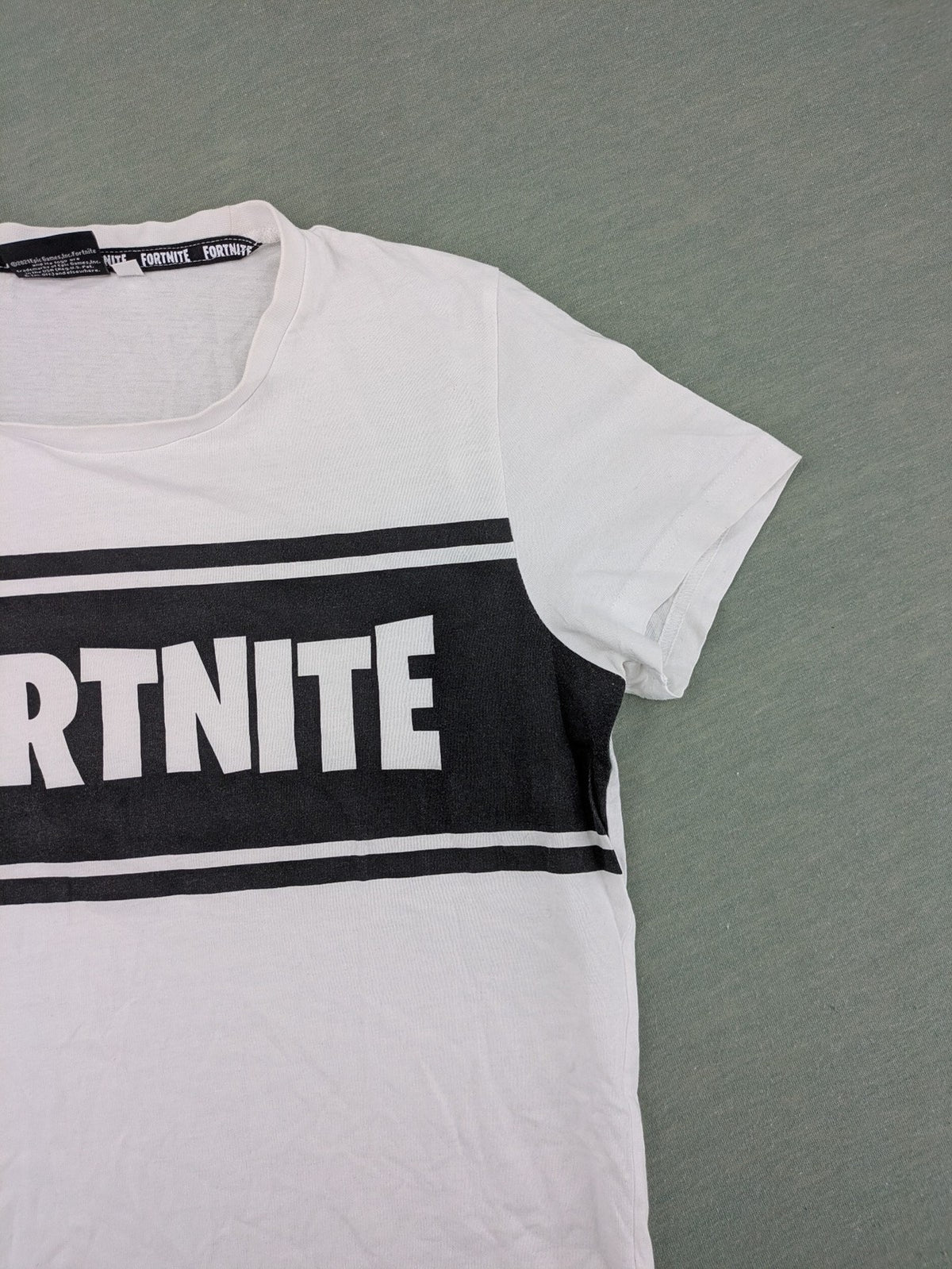 Fortnite white t-shirt with black chest stripe and Epic Games logo, 100% cotton.