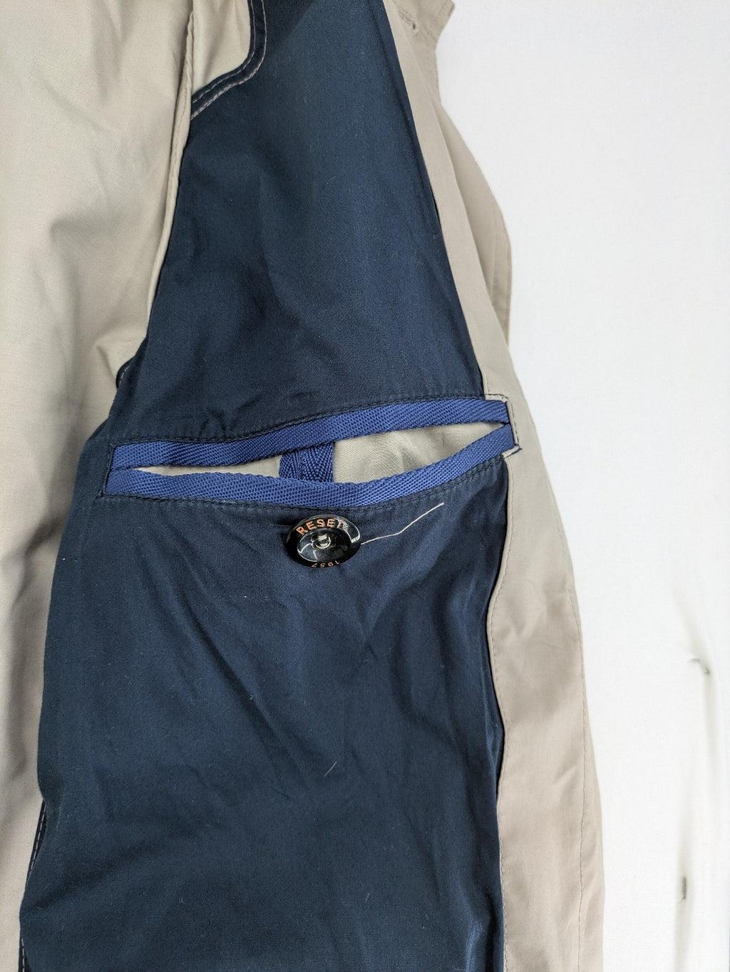 ReSET beige coat with contrasting dark blue lining and classic design details.