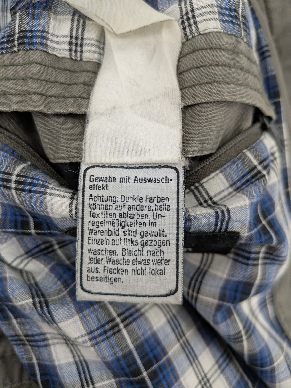 Walbusch khaki military jacket with checkered blue-white lining and multiple pockets.