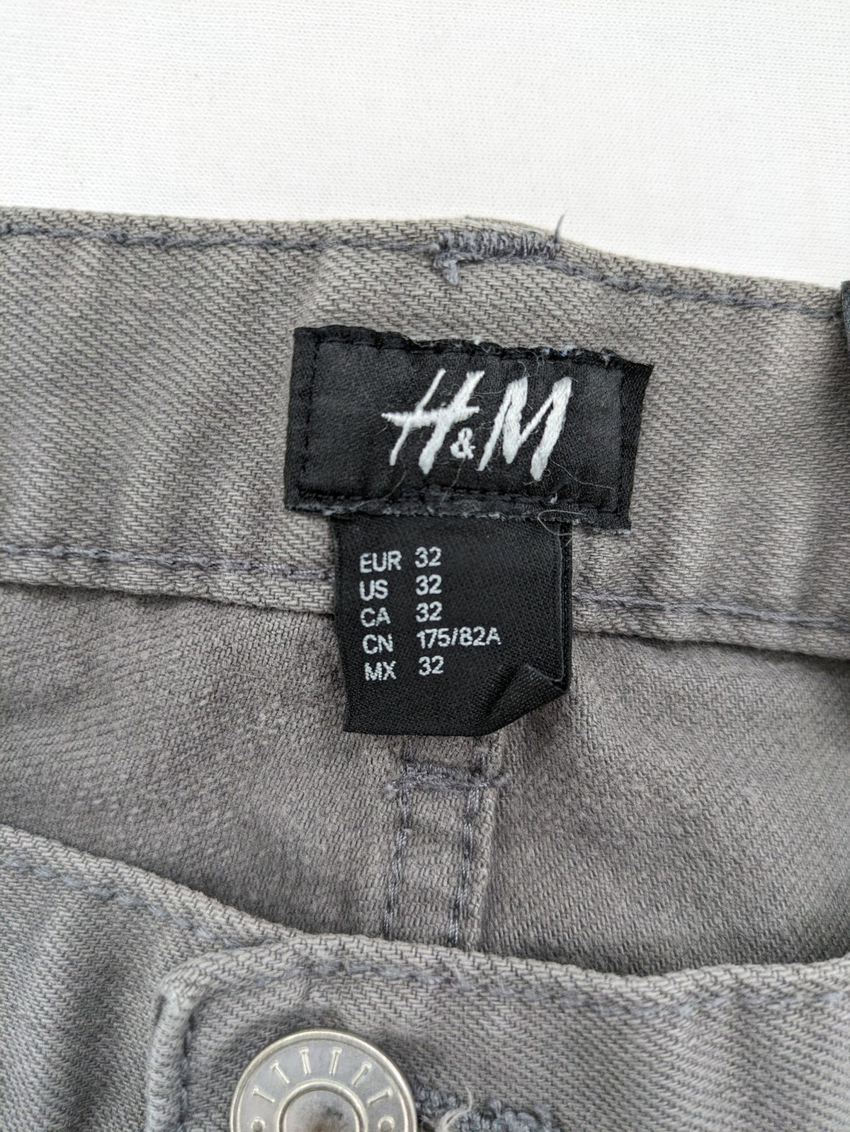 H&M grey skinny fit jeans with button closure and five-pocket design, cotton-elastane blend.