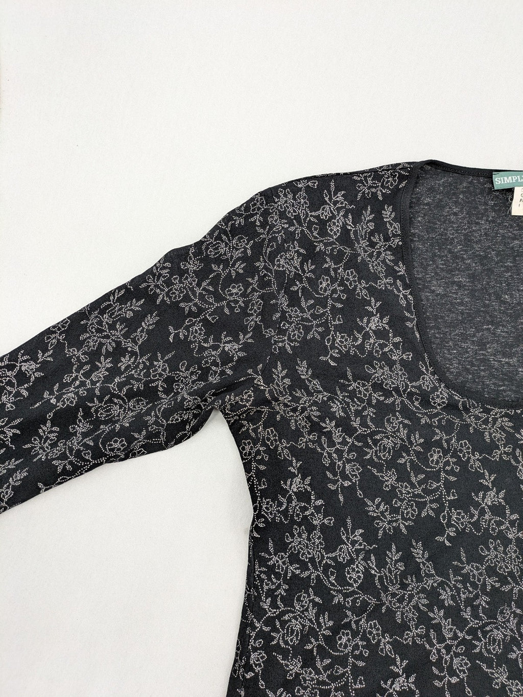 Simply The Best black top with white floral pattern and gathered front detail.