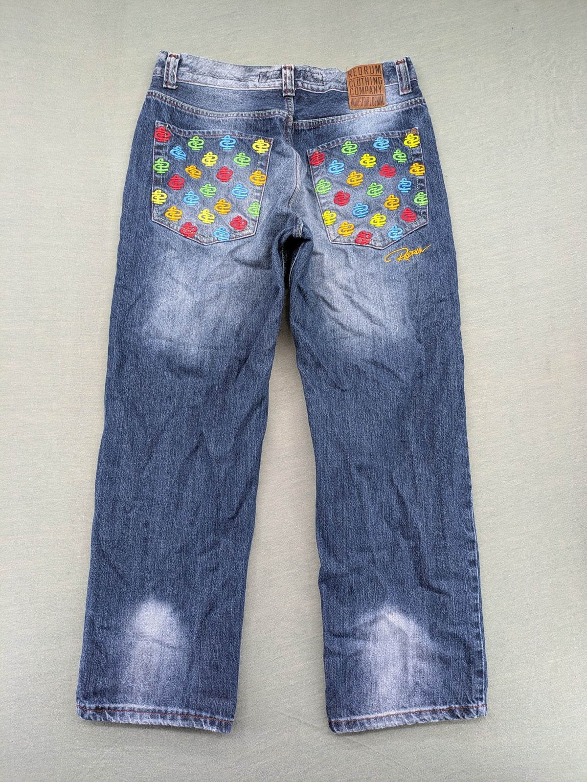 Y2K blue straight jeans with colorful logo embroidery and baggy fit.