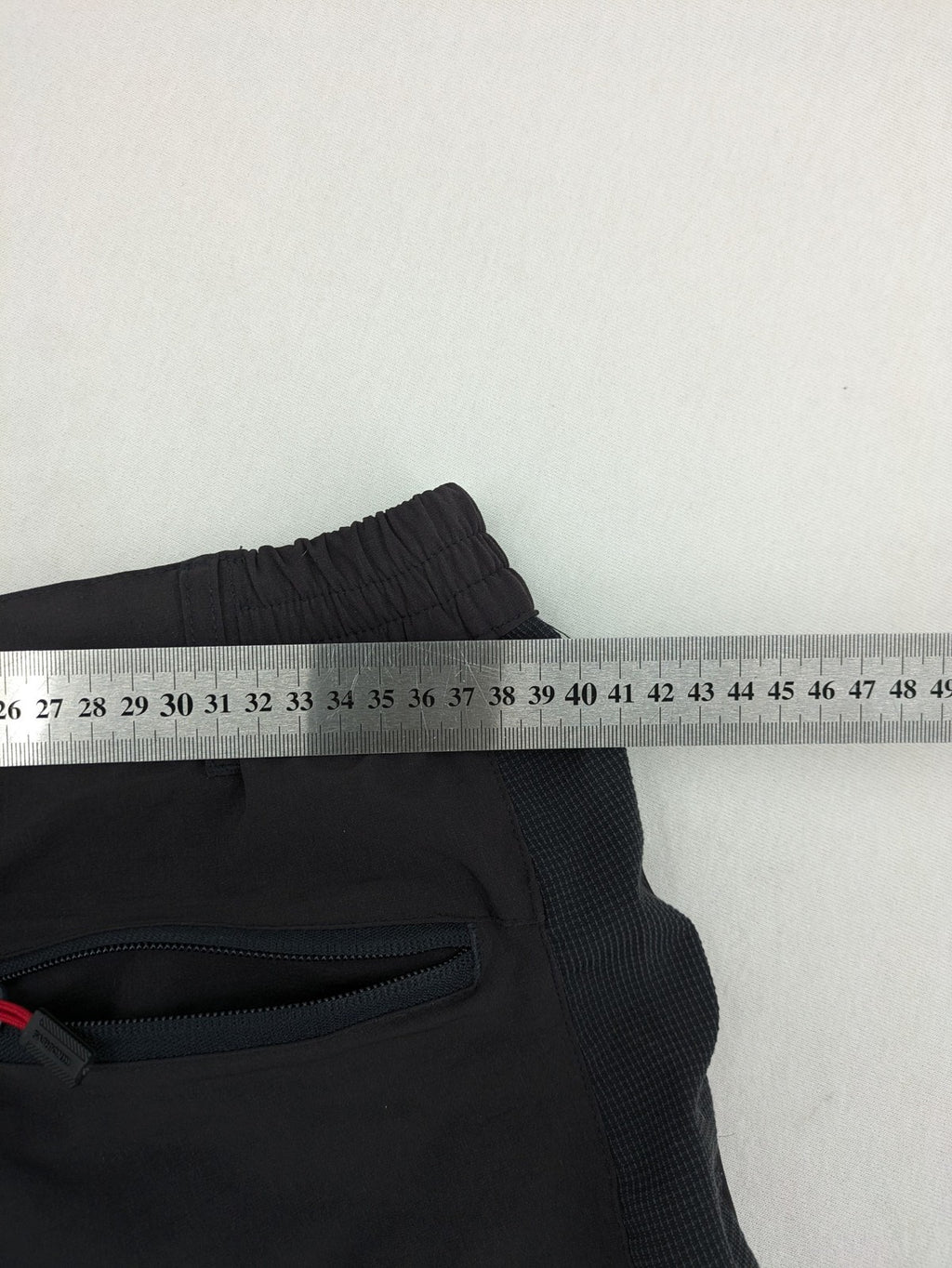 Outdoor black capri pants with elastic waistband and multiple zippered pockets.