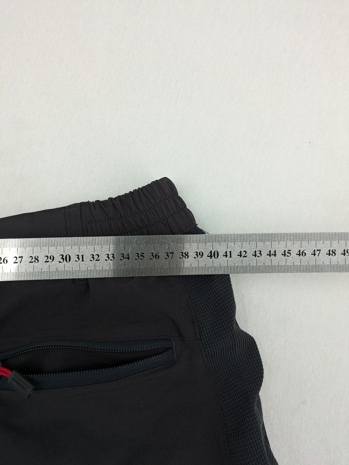 Outdoor black capri pants with elastic waistband and multiple zippered pockets.