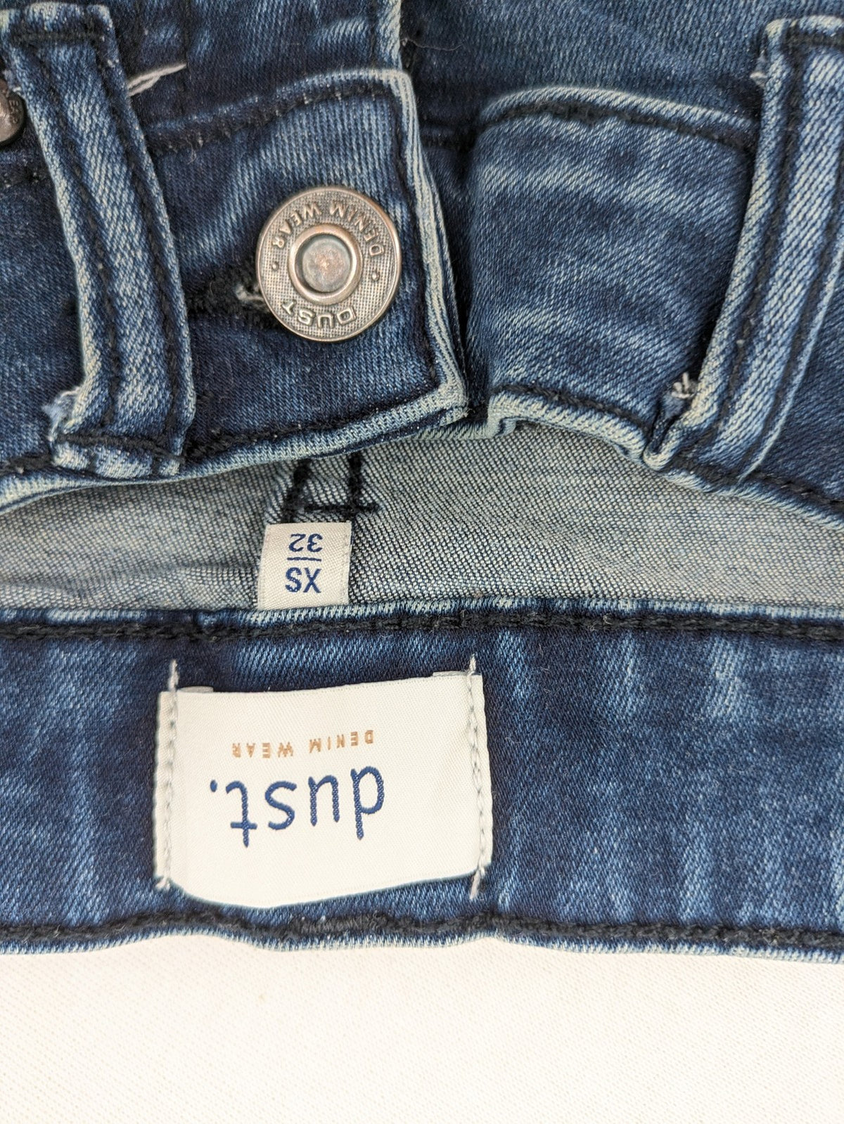 Dust blue skinny jeans with mid-rise waist and classic wash, stretch denim material.
