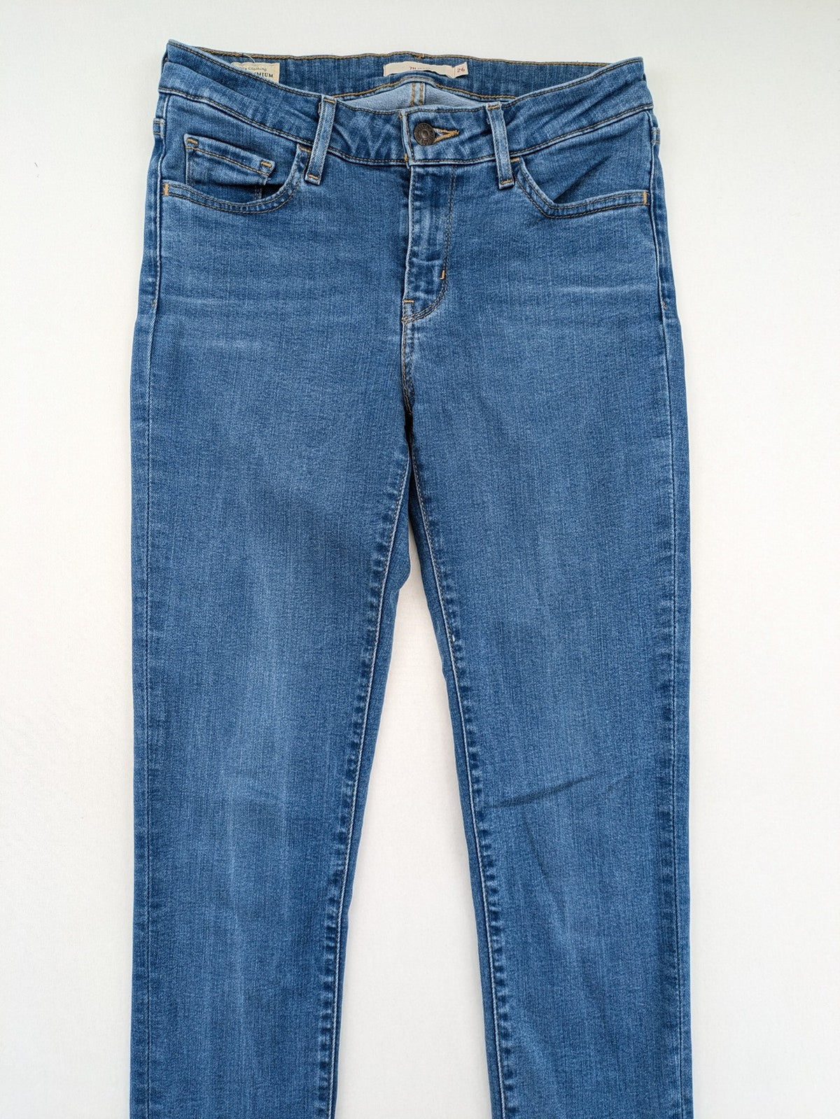 Levi's blue skinny jeans with raw hem, classic five-pocket design, and zip fly.
