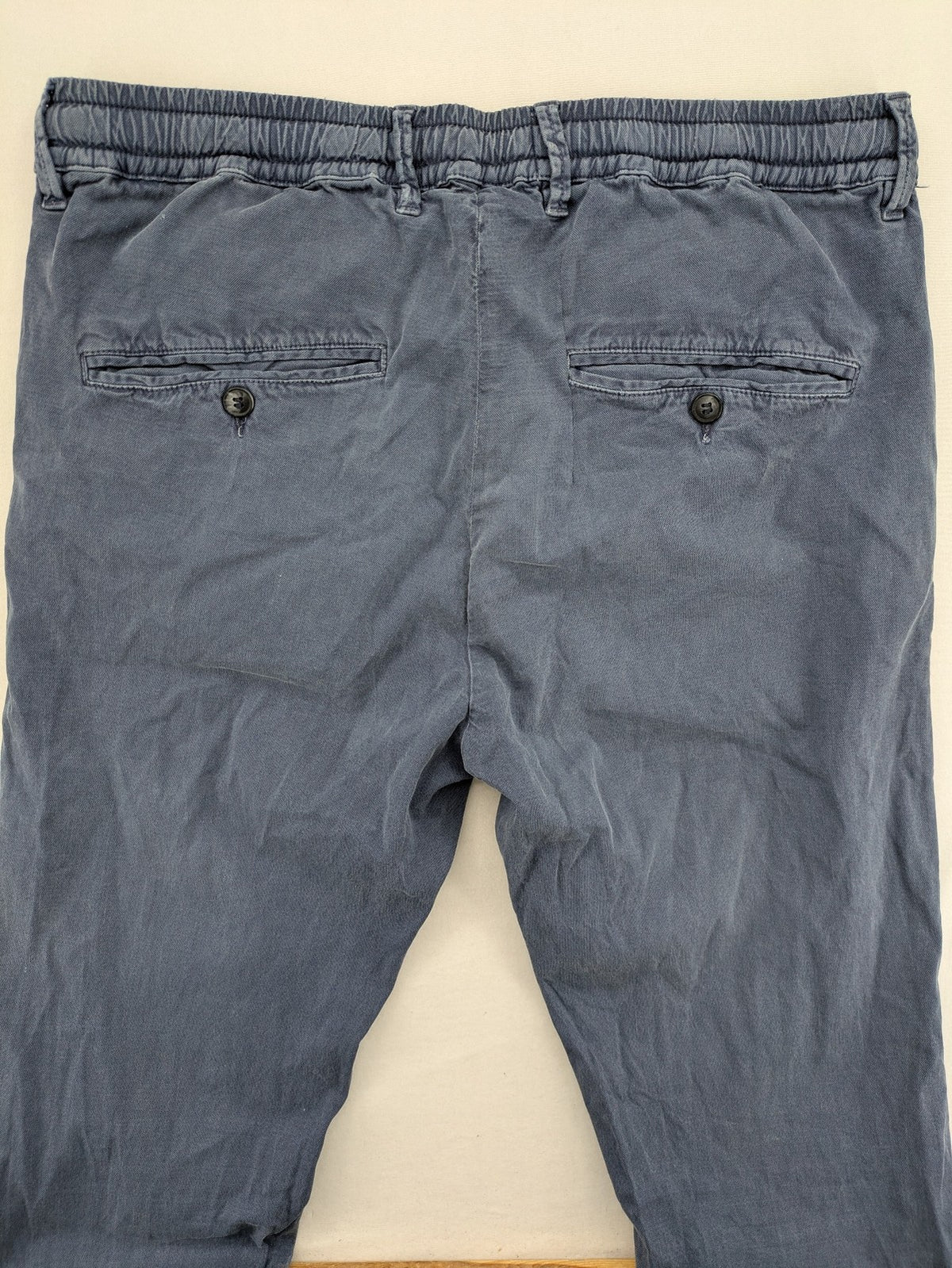 Spaghetti Mafia cream pants with elastic waistband, drawstring, and subtle front pleats.