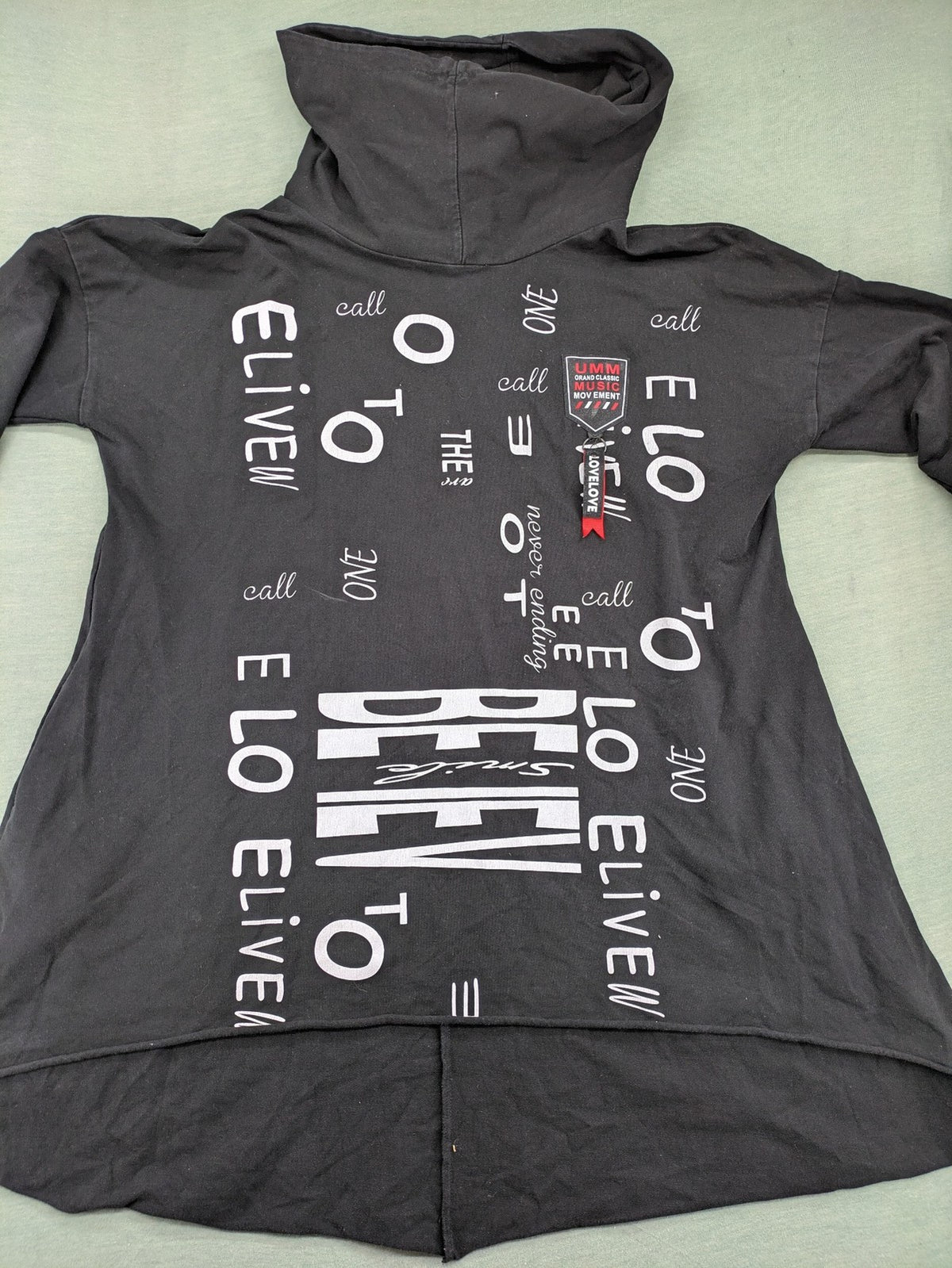 MEGI Collection black hoodie dress with graphic print and asymmetrical high-low hem.