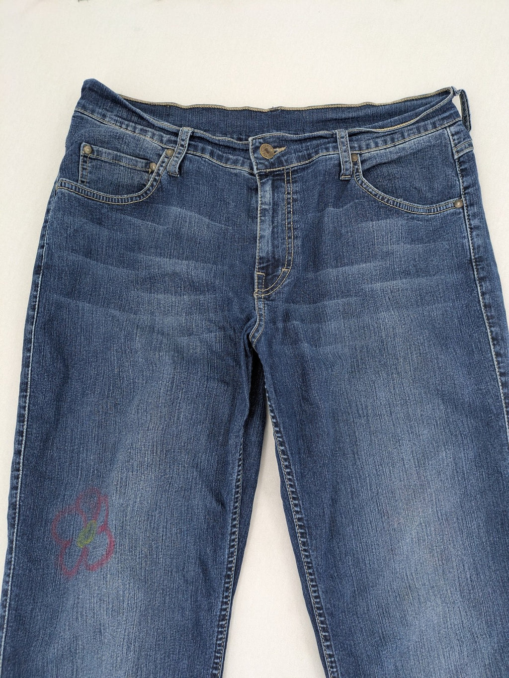 Mustang blue bootcut jeans with custom painted floral designs on both legs.