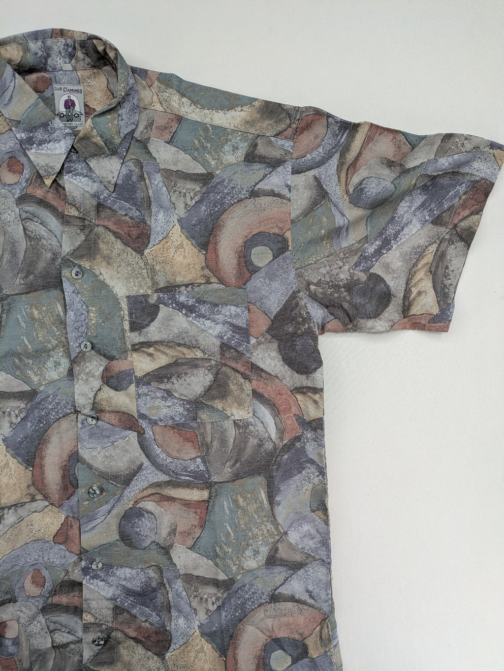 Club D'Amingo short sleeve shirt multi abstract geometric pattern in earthy tones.