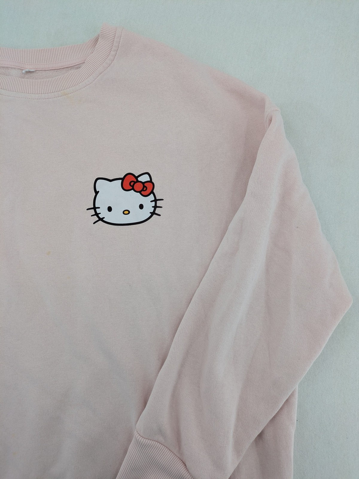 Hello Kitty pink sweatshirt classic graphic face logo on chest, long sleeves, round neck.