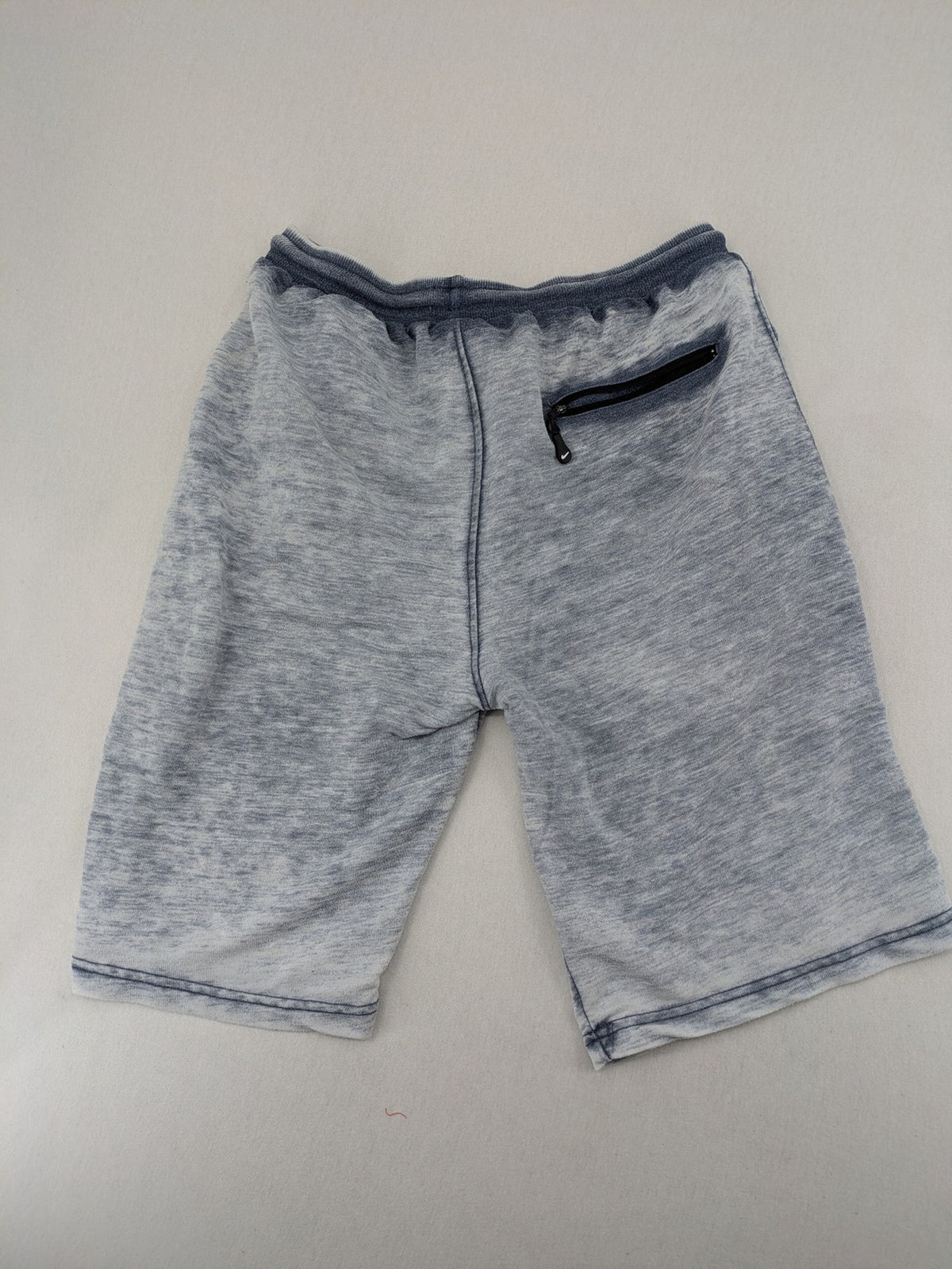 Nike grey acid wash jogger shorts with embossed logo and zip pockets.