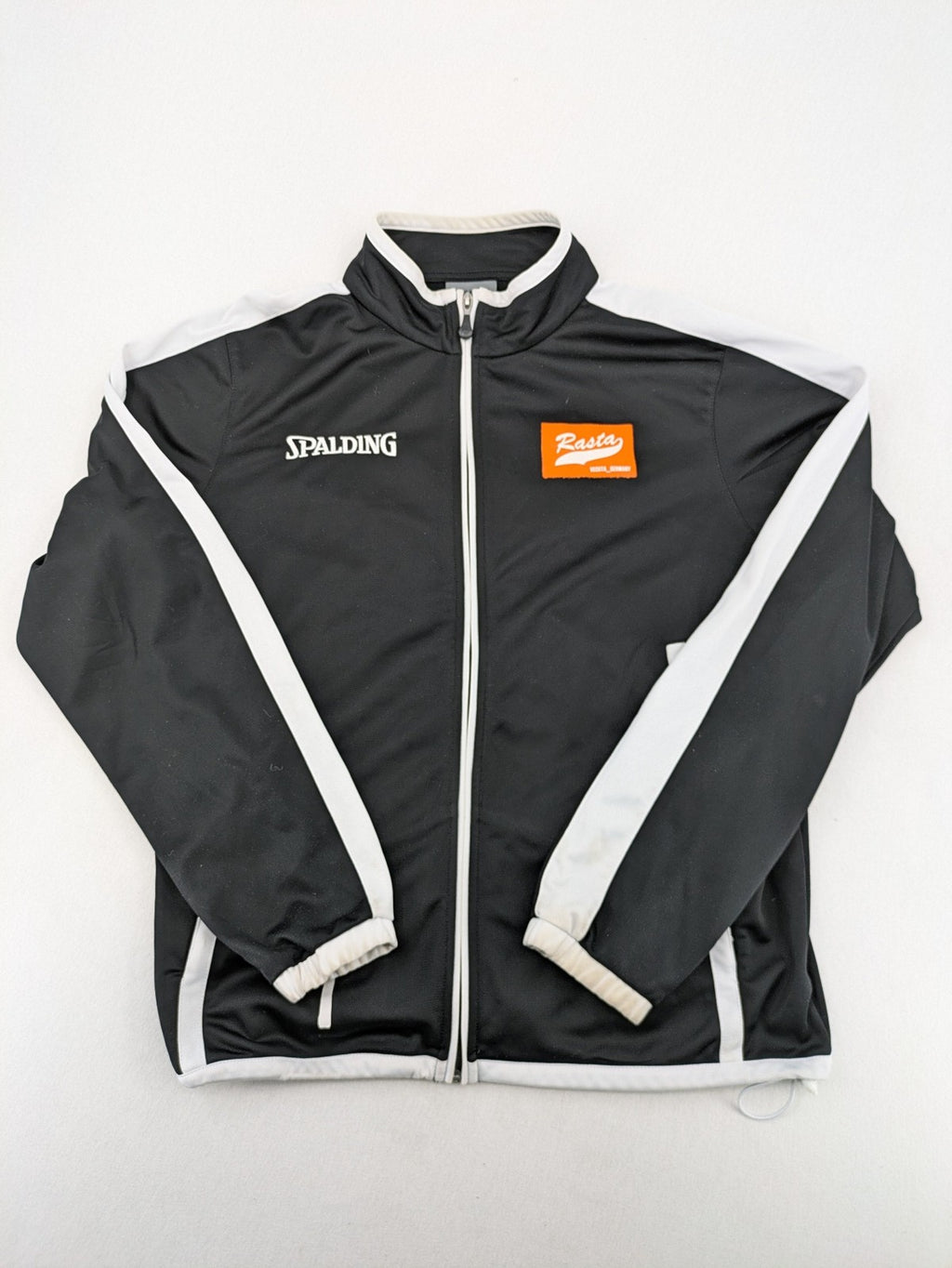 Spalding black training jacket with orange and white accents, Rasta Vechta logo, zip front.