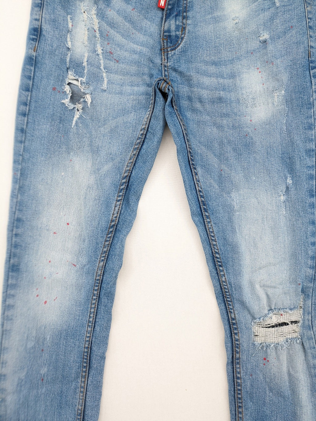 Milano straight jeans light blue distressed with red splatter and extra slim fit.
