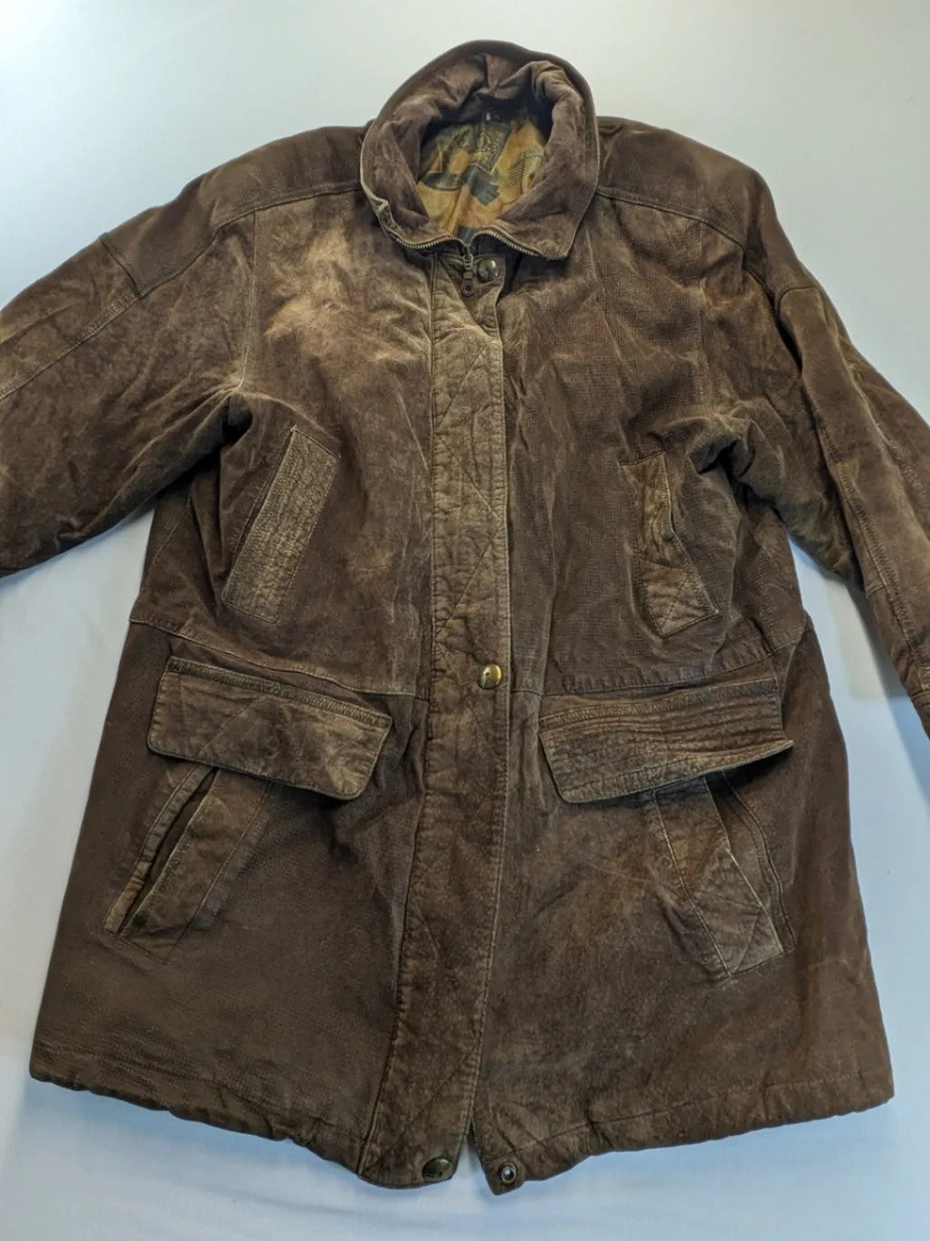 Vintage brown leather jacket with graphic lining, zip closure, and button placket.