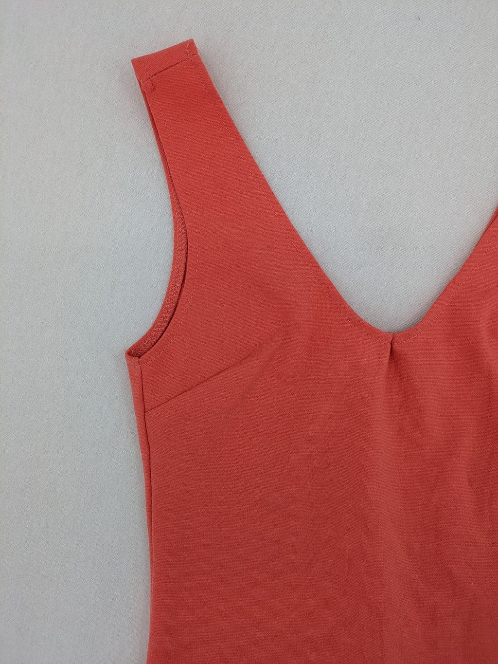 Zebra orange bodycon mini dress with deep V-neck and sleeveless design.
