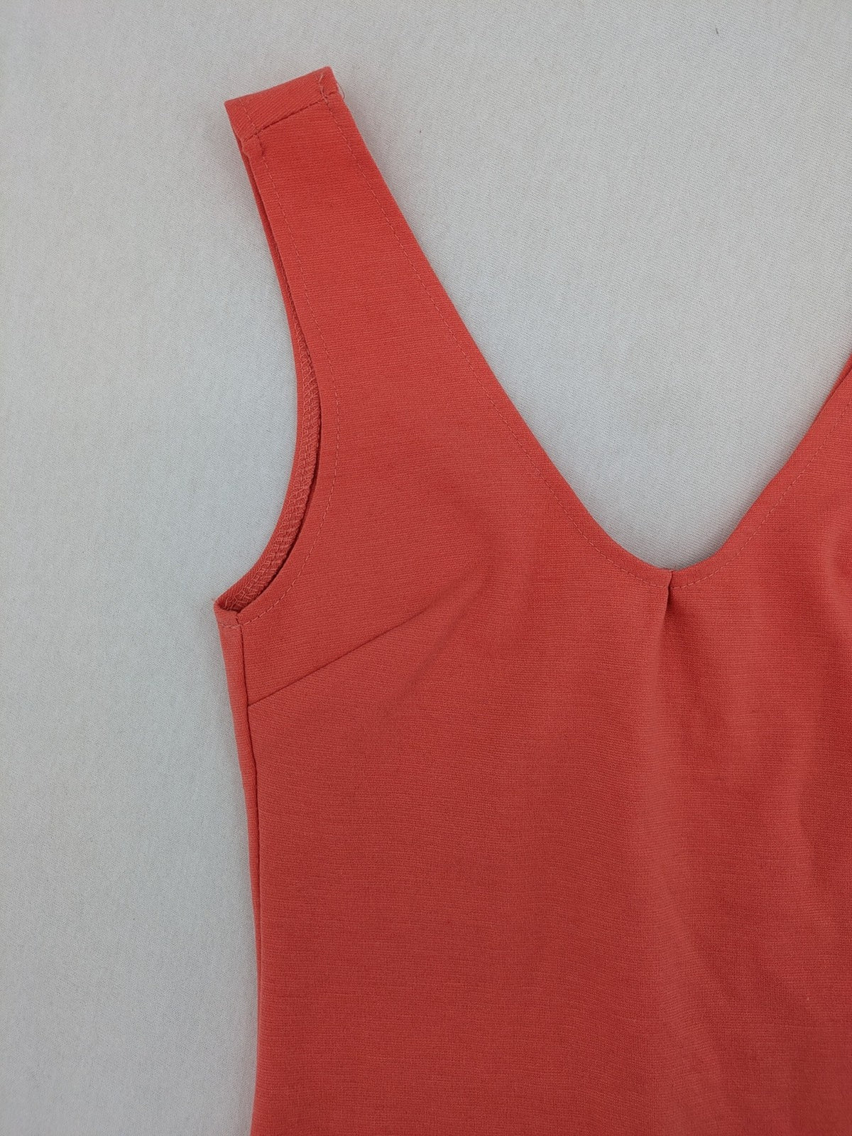 Zebra orange bodycon mini dress with deep V-neck and sleeveless design.