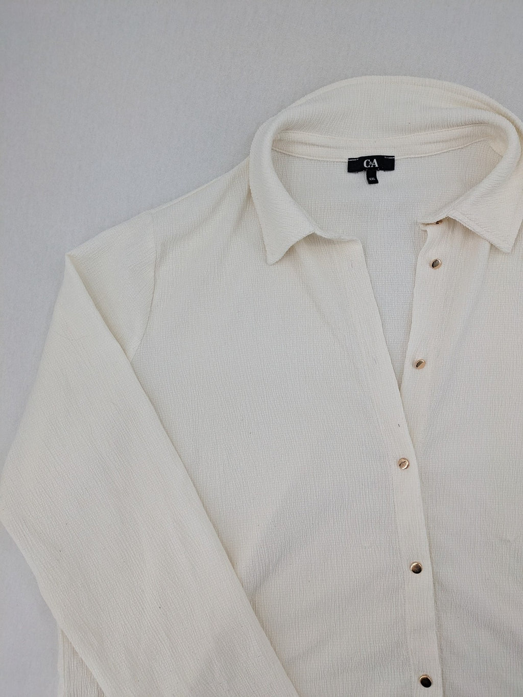 C&A cream blouse XXL textured crinkle fabric with gold button placket and wavy hem.