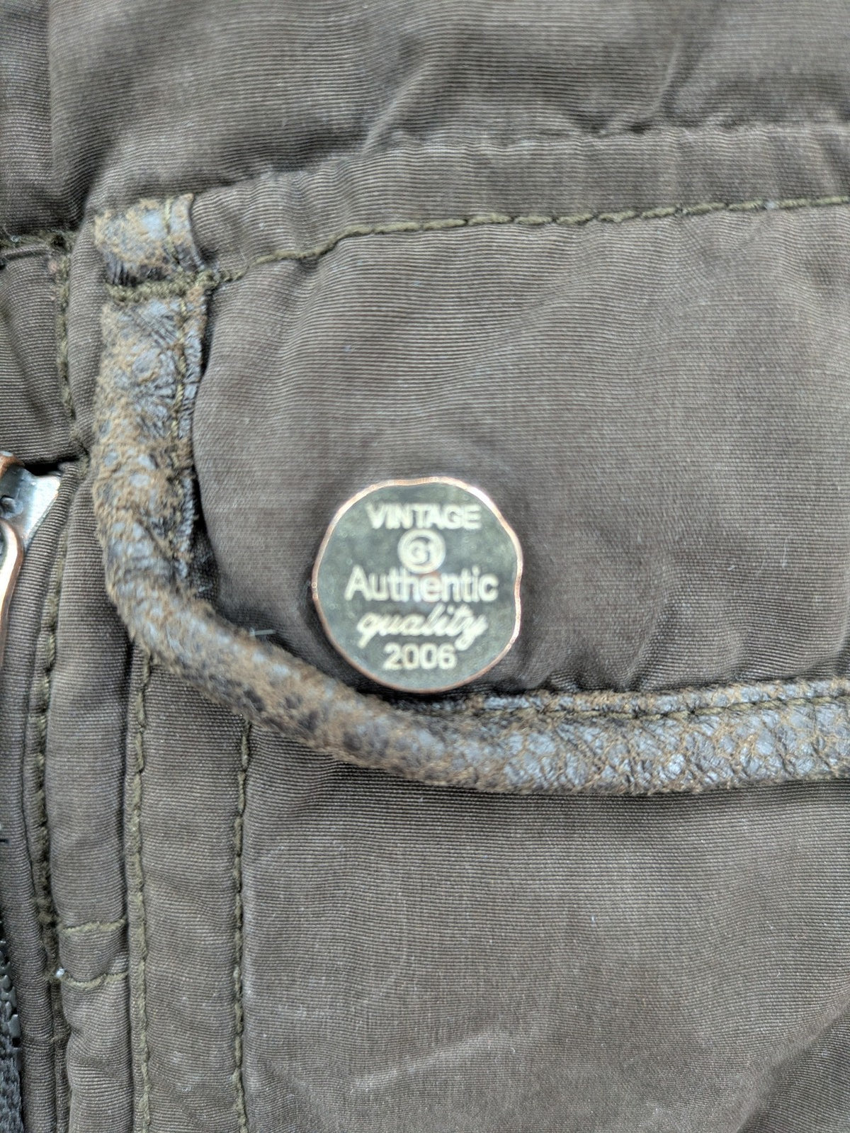 Gate One brown field jacket with plaid lining, multiple pockets, and zip-button closure.