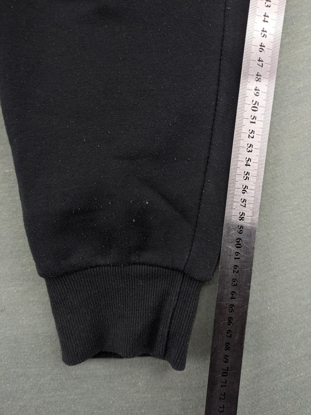 McKenzie black joggers with white logo, tapered fit, and ribbed ankle cuffs.