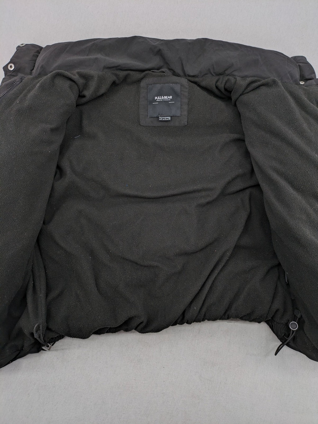 Pull&Bear black puffer coat with high collar, fleece lining, and quilted design.