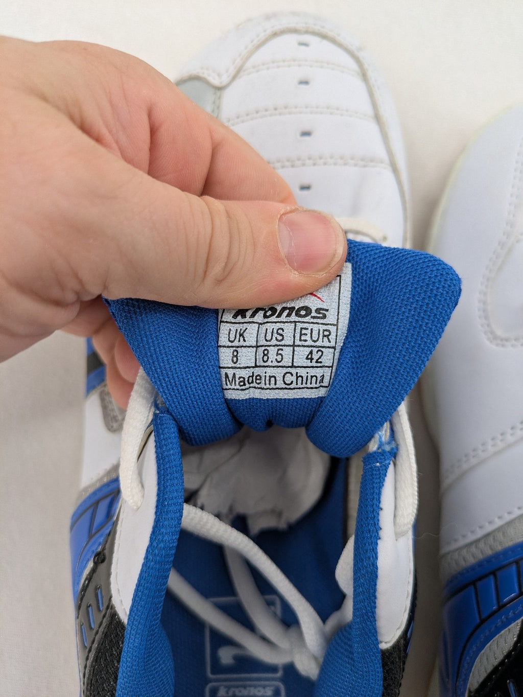 Kronos sports sneakers white, blue, and silver with durable rubber sole and classic design.