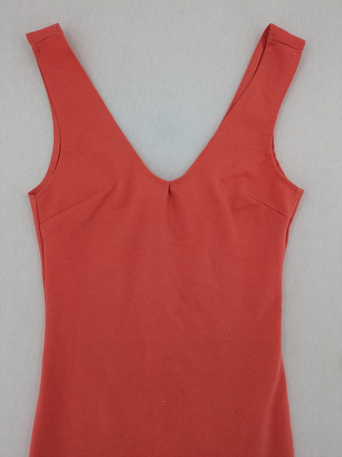 Zebra orange bodycon mini dress with deep V-neck and sleeveless design.