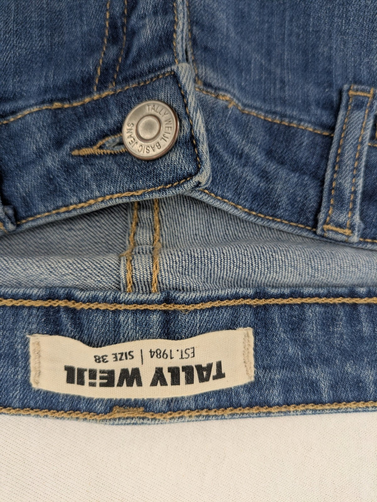Tally Weijl blue bootcut jeans with distressed knees and raw hem detail.