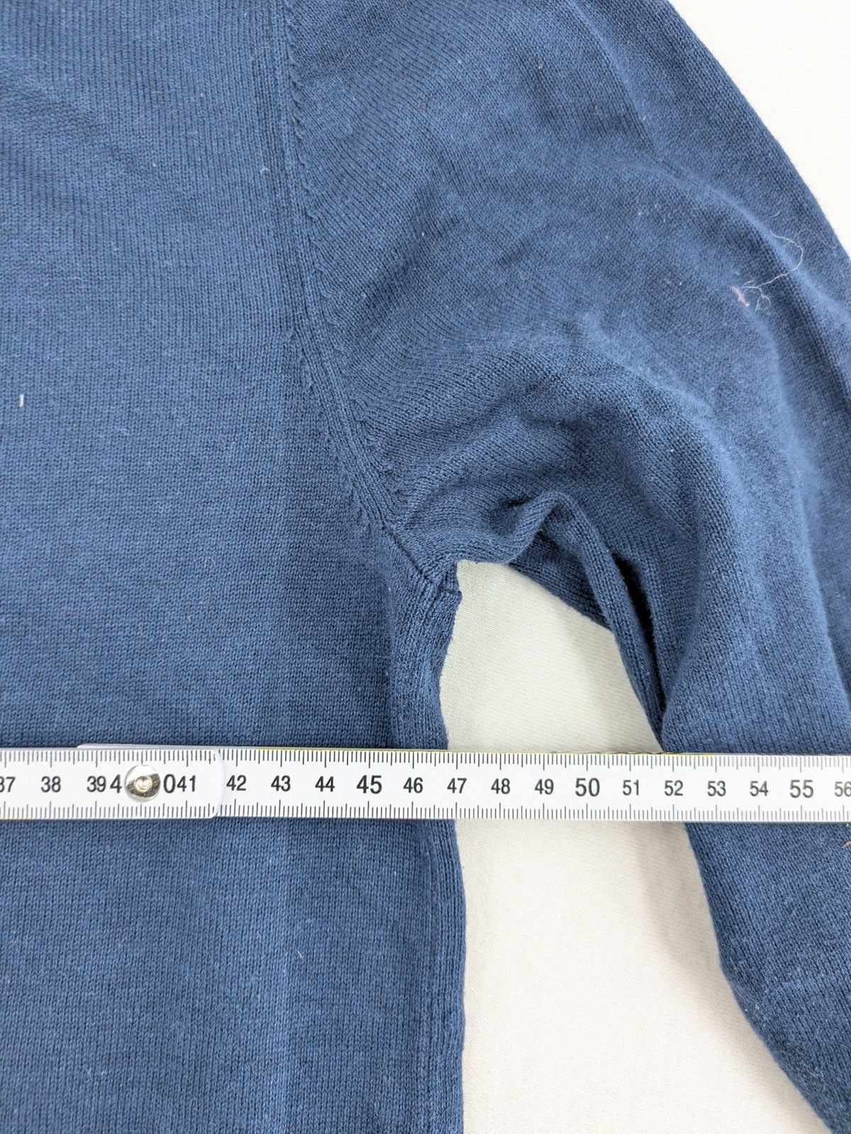 Queen blue knit jumper with embroidered crest logo, V-neck, 100% cotton.