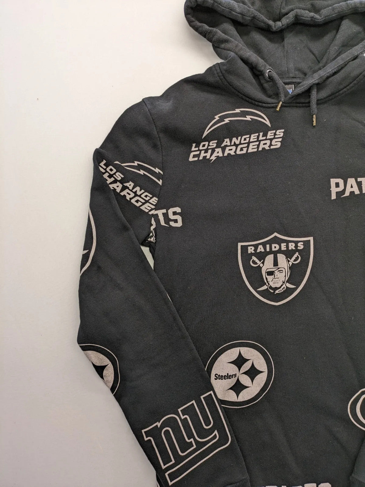NFL black hoodie all-over team logo print, adjustable hood, cotton blend material.