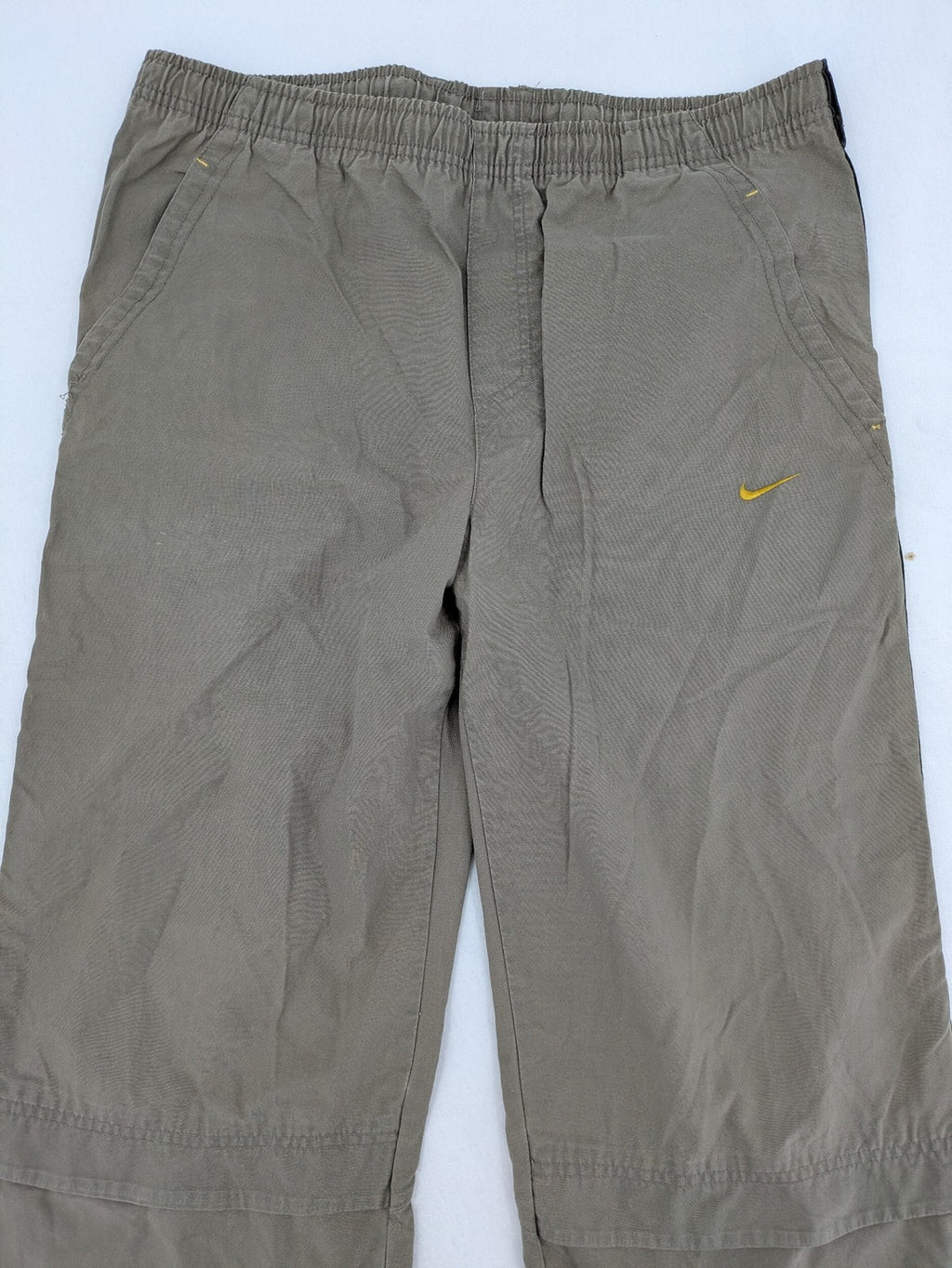 Nike khaki training pants with logo, elastic waistband, and practical pockets.