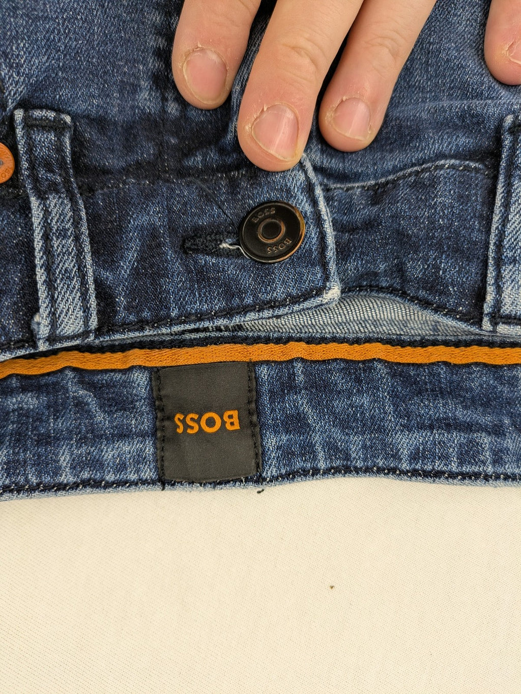 BOSS blue slim fit jeans with logo, five-pocket design, and button fly.