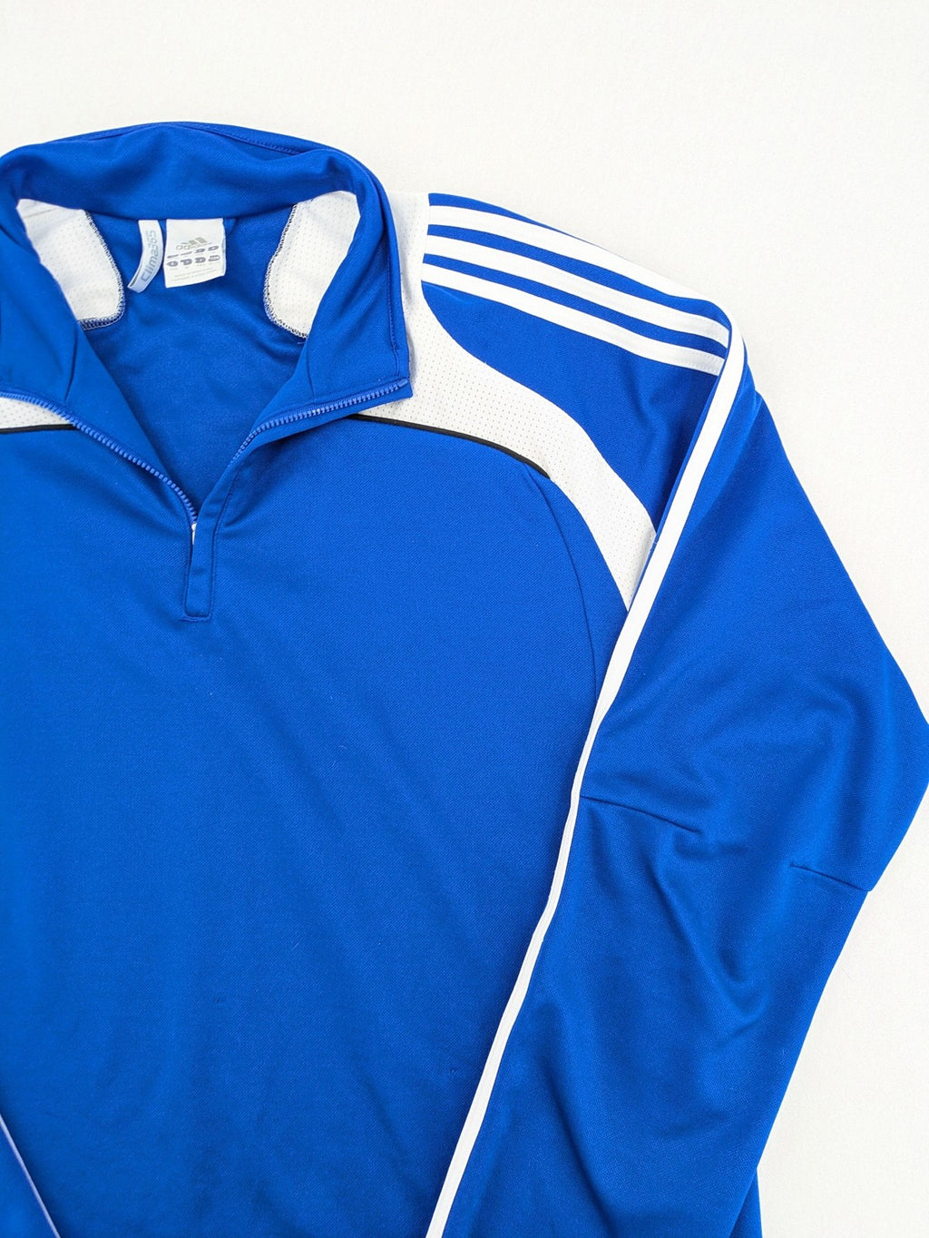 Adidas blue long sleeve top with white three stripes and 1/4 zip collar.