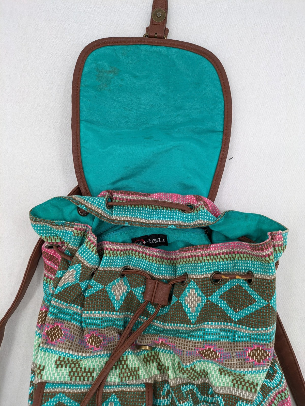 Boho multi backpack with vibrant Aztec tribal print and brown faux leather accents.