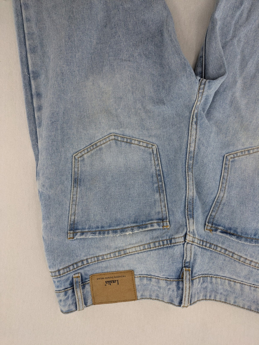 Laulia blue wide leg jeans with distressed knee rips and high waist design.