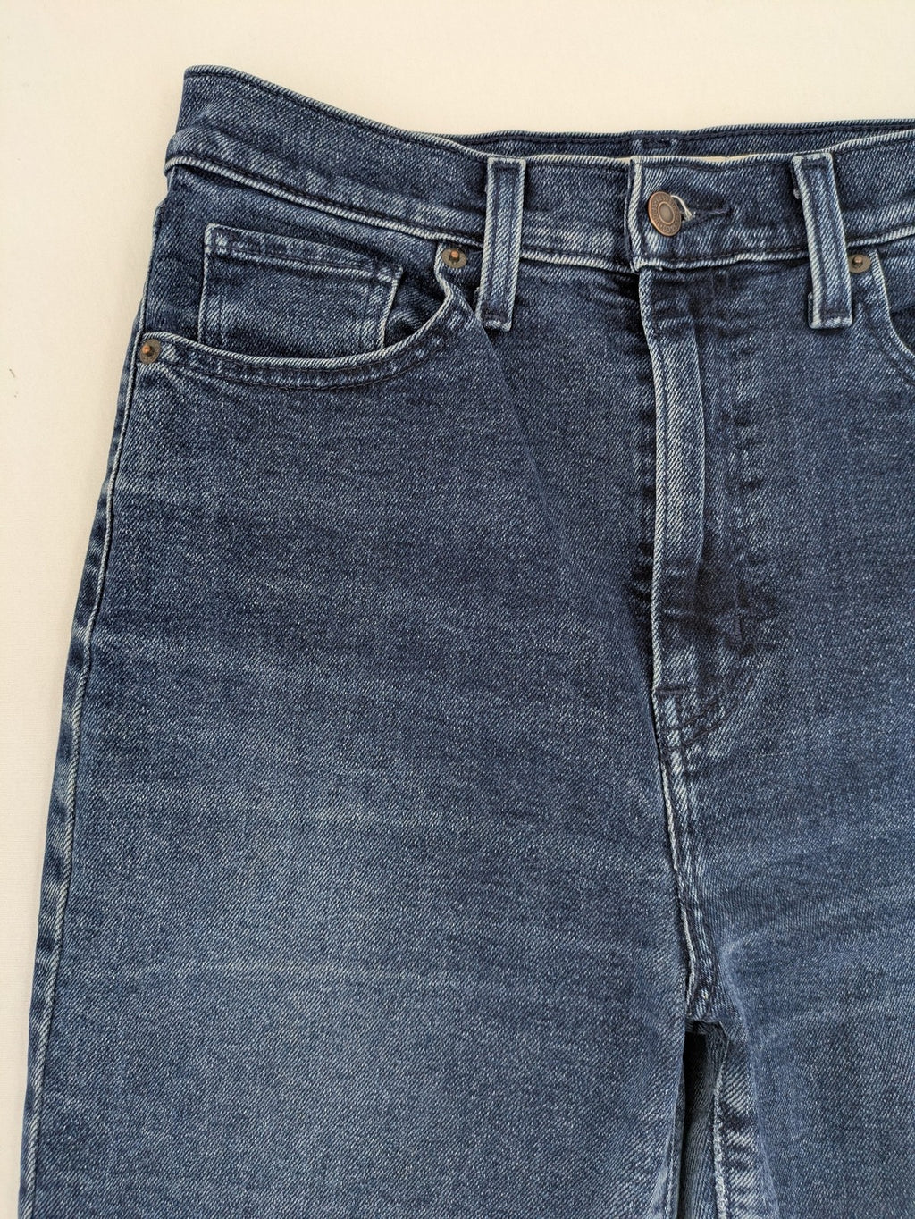 Levi's high waisted taper jeans dark blue 5-pocket design with zipper and stretch material.