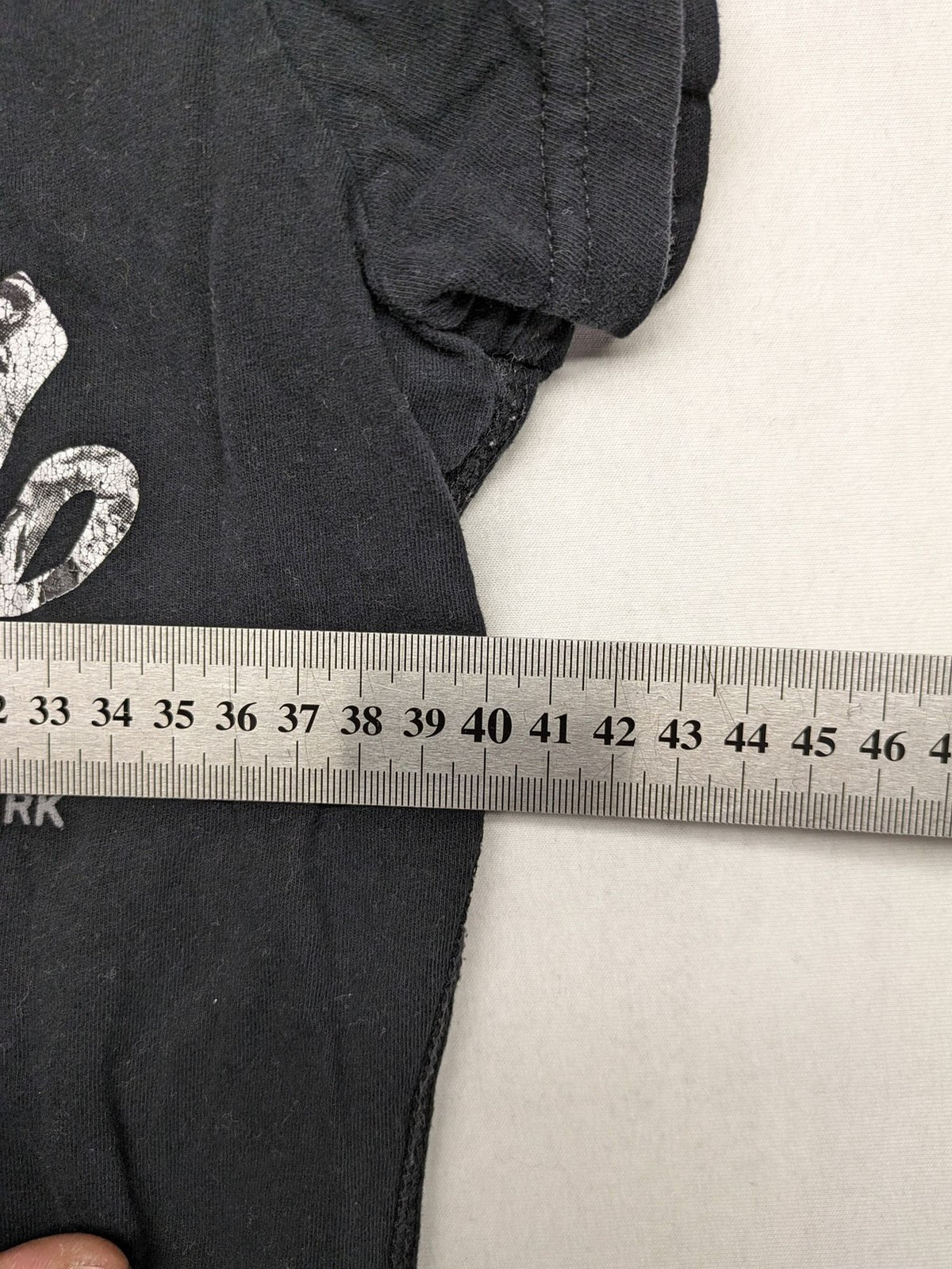 Superdry black t-shirt with large Osaka Brand logo and subtle floral pattern.