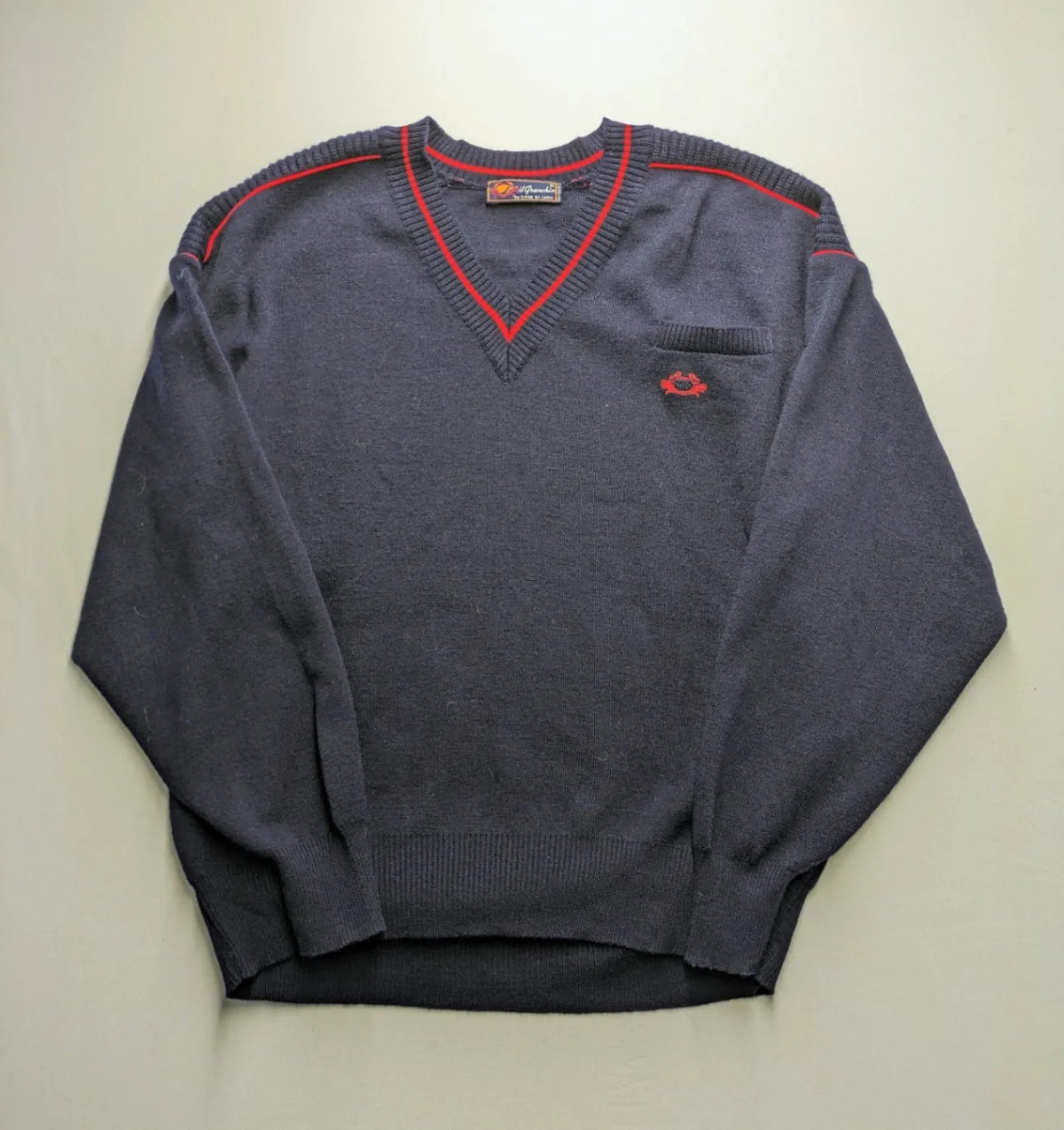 Il Granchio grey turtle neck jumper with red accents and embroidered crab logo.